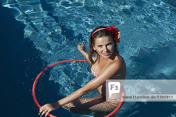 Woman playing with hula hoop in pool