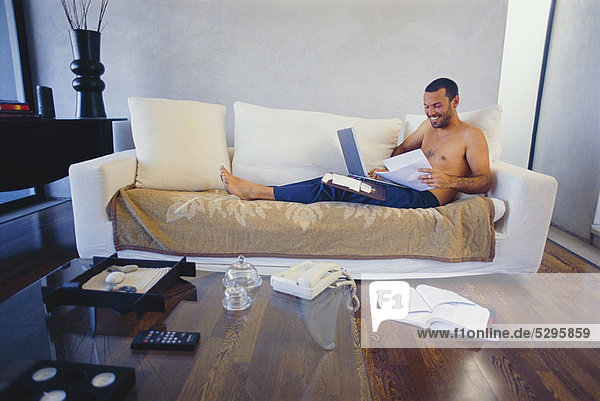 Man studying with laptop in living room
