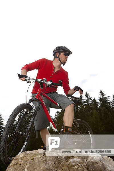 Man with mountainbike on rock peak