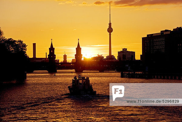 Oberbaumbruecke bridge  boat  sunset  Berlin  Germany  Europe