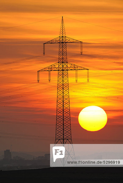 Electric power transmission lines  electricity pylon  with the setting sun  Beinstein near Stuttgart  Baden-Wuerttemberg  Germany  Europe