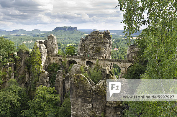 View of the rocks of the Bastei and the Basteibruecke bridge  behind Mt. Lilienstein  Elbe Sandstone Mountains  Saxony  Germany  Europe