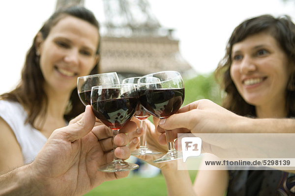 Friends clinking wine glasses outdoors