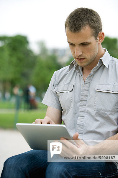 Mann mit digitalem Tablett im Freien