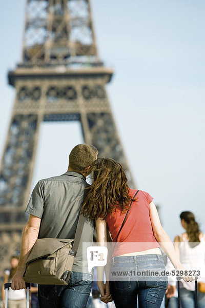 Tourist couple walking hand in hand toward Eiffel Tower  Paris  France
