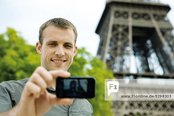 Man photographing himself in front of Eiffel Tower  Paris  France