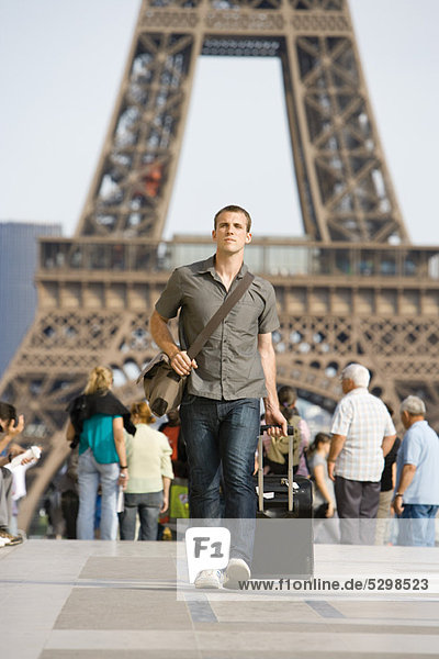 Male tourist walking with luggage  Eiffel Tower  Paris  France