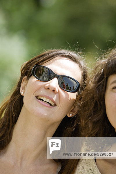 Woman beside friend  smiling  portrait
