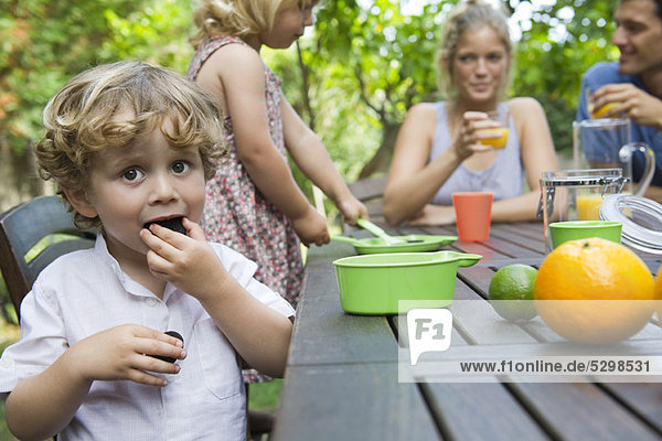 Junge genießt Outdoor-Snack mit seiner Familie