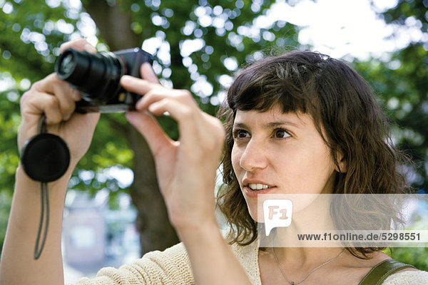 Woman taking picture with digital camera