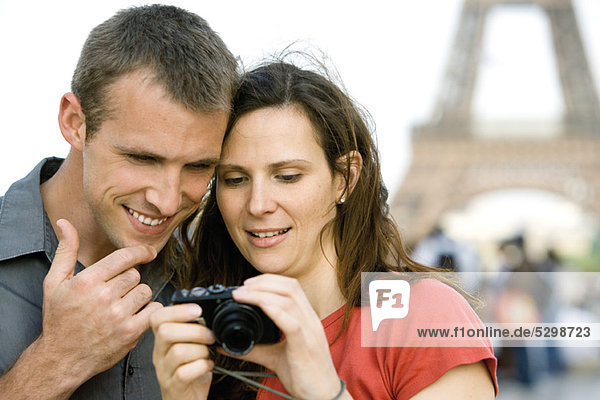 Couple looking at pictures on digital camera