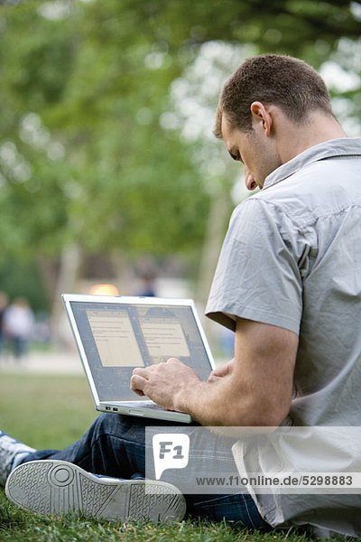 Mann mit Laptop-Computer im Freien