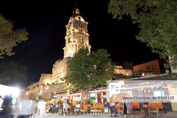 Clock tower  Odos Orfeas shopping street with sidewalk cafes at night  historic district of Rhodes  Rhodes  Greece  Europe  PublicGround
