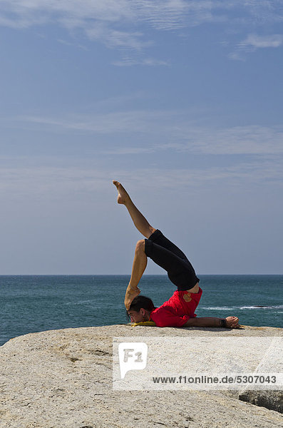 Frau in Yoga-Position Salabhasana  am Meer in Kanyakumari  Tamil Nadu  Indien  Asien