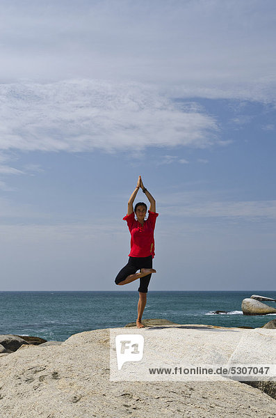 Woman in a yoga position  Vrikshasana  by the sea in Kanyakumari  Tamil Nadu  India  Asia