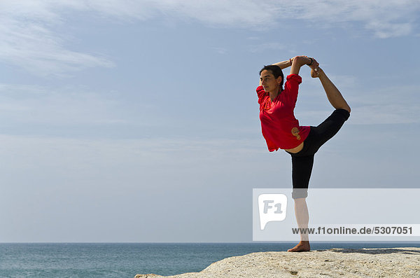 Woman in a yoga position  Natarajasana  by the sea in Kanyakumari  Tamil Nadu  India  Asia