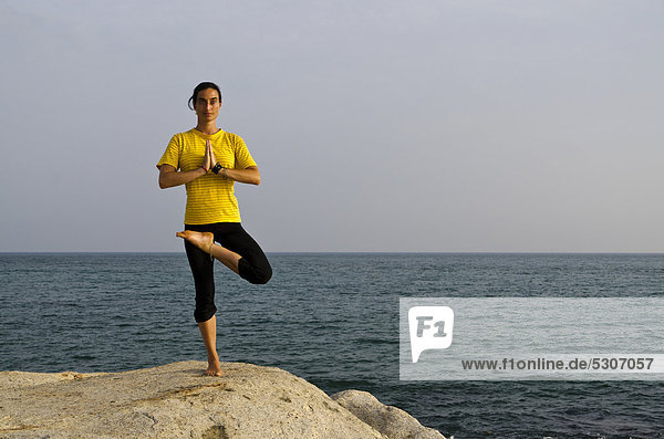 Frau in Yoga-Position Vrikshasana  am Meer in Kanyakumari  Tamil Nadu  Indien  Asien