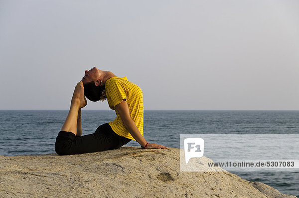 Frau in Yoga-Position Bhujangasana  am Meer in Kanyakumari  Tamil Nadu  Indien  Asien