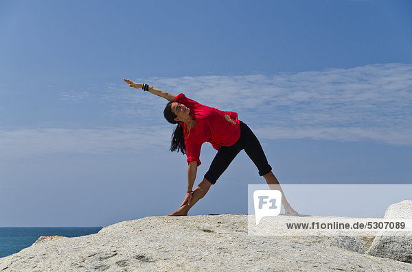 Frau in Yoga-Position Trikonasana  am Meer in Kanyakumari  Tamil Nadu  Indien  Asien