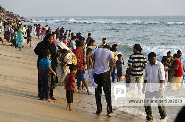 Indian tourists having a swim  fully dressed  in the ocean at the local beach of Varkala  Kerala  India  Asia