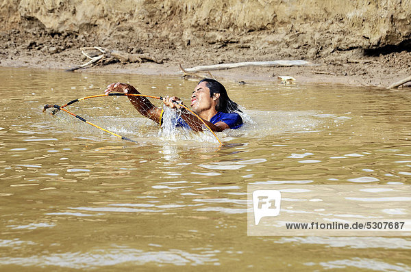 Junger Mann fischt mit Netz im Fluss Pilcomayo  Indigenen-Gemeinde La Curvita  in der Sprache der Wichi-Indianer: Hothaj  Gran Chaco  Salta  Argentinien  Südamerika