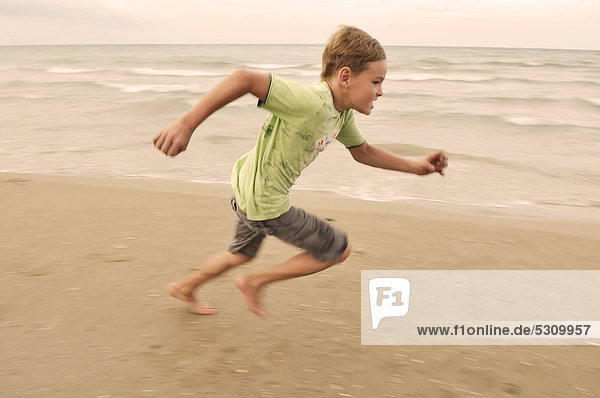 7jähriger Junge läuft am Strand entlang  Roseto degli Abruzzi  Abruzzen  Italien  Europa