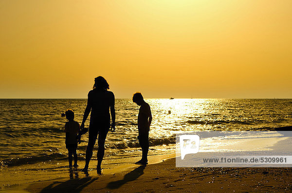 Mother with two children standing on the beach  evening mood  Lido di Ostia  Rome  Lazio region  Italy  Europe