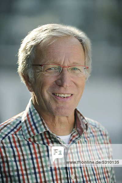 Sympathischer Alterer Mann Anfang Sechzig Mit Brille Portrat