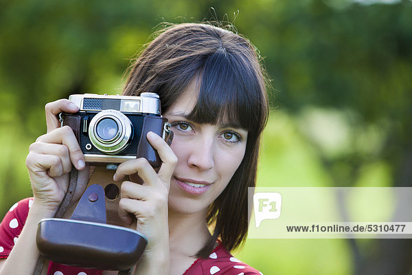 Young woman  25  holding an old camera