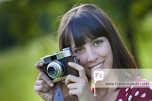 Young woman  25  holding an old camera