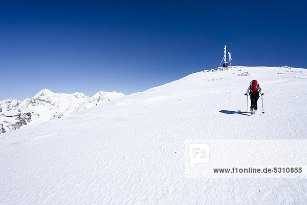Cross-country skier ascending Hintere Schoentaufspitze Mountain  Solda in winter  looking towards the summit with a weather station  Alto Adige  Italy  Europe