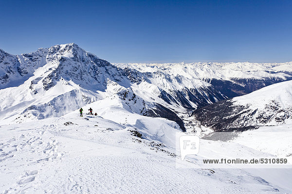 Cross-country skiers descending Hintere Schoentaufspitze Mountain  Solda in winter  looking towards Ortler Mountain and Solda Valley  Alto Adige  Italy  Europe