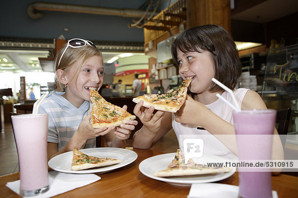 Two girls  10  eating pizza