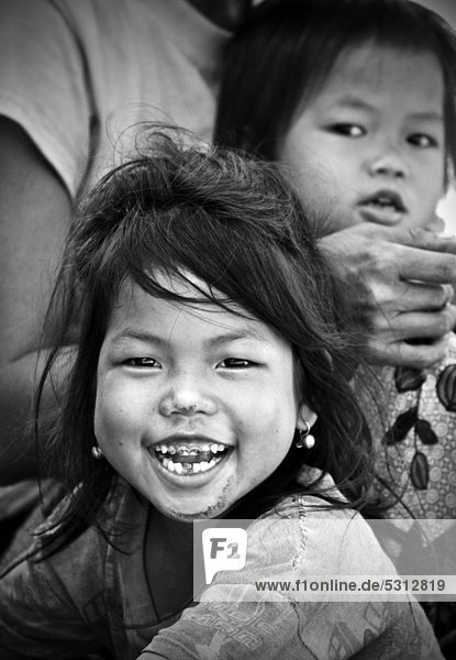 Lachendes Mädchen mit faulen Zähnen  dahinter ein weiteres Kind  in Laos  Südostasien  Asien