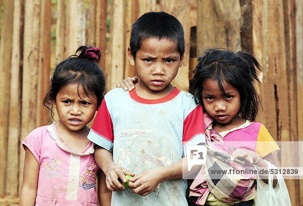 Three children looking critically towards the camera  Laos  Southeast Asia  Asia