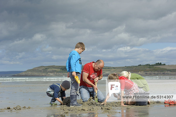 Young anglers and an adult digging for sandworms (Arenicola marina) on the beach  Atlantic Ocean  Finistere  Brittany  France  Europe  PublicGround