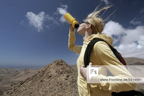 Frau  trinken  Flasche  wandern  Bergsteigen  Aussicht  Gran Montana  bei Pajara  Fuerteventura  Kanarische Inseln  Spanien  Europa