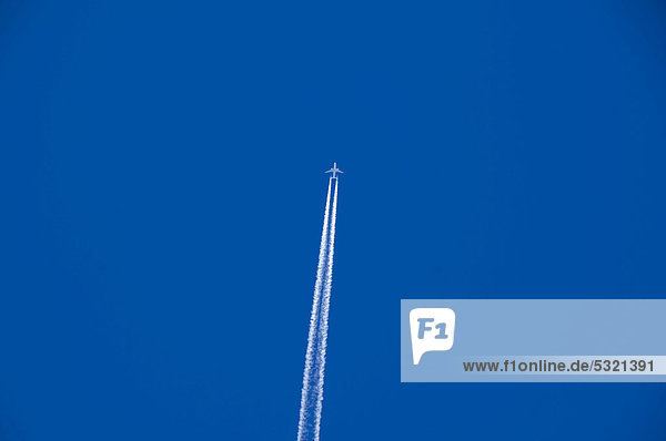 Flugzeug hinterlässt Kondensstreifen am blauen Himmel