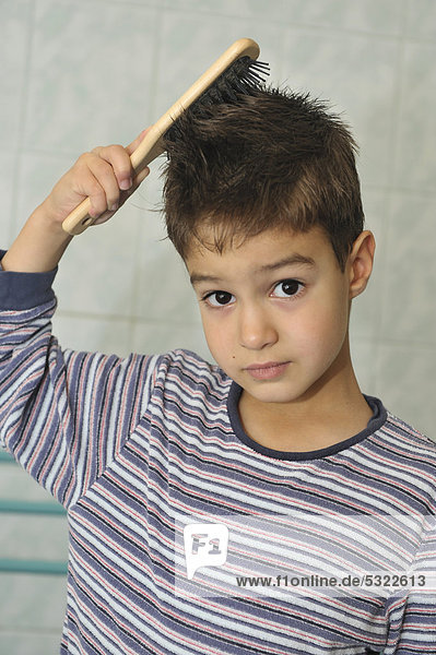 Junge  5 Jahre  bürstet sich im Badezimmer die Haare