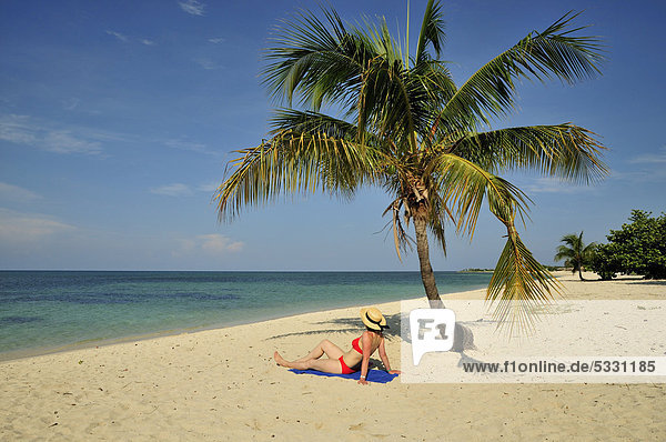 Touristin unter einer Palme am Strand  Playa AncÛn  bei Trinidad  Kuba  Karibik