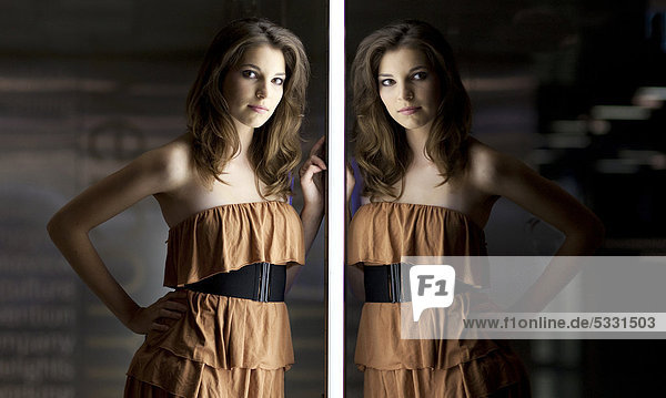 Young woman in a beige dress with reflection