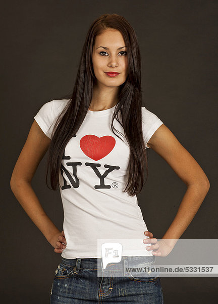 Junge Frau posiert selbstbewusst in weißem T-Shirt mit der Aufschrift I love NY