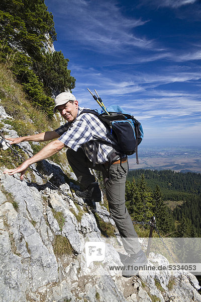 Mann  55 Jahre  auf Klettersteig auf das Ettaler Manndl am Laberberg in den Ammergauer Alpen  Ettal  Oberbayern  Bayern  Deutschland  Europa