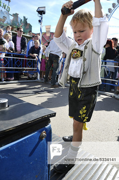5jähriger Junge mit Lederhose und Trachtenjacke haut den Lukas  Oktoberfest 2010  München  Oberbayern  Bayern  Deutschland  Europa