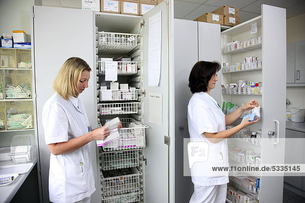 Krankenschwestern in der Stationsapotheke bereiten Medikamente für die Patienten vor  Krankenhaus