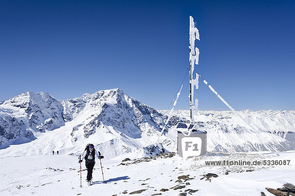 Skitourengeher auf dem Gipfel der hinteren Schöntaufspitze mit der Wetterstation  hinten der Ortler und der Zebru  Sulden im Winter  Südtirol  Italien  Europa