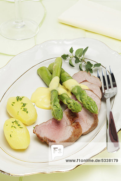 Schweinefiletbraten mit grünem Spargel  Sauce Hollandaise und neuen Kartoffeln