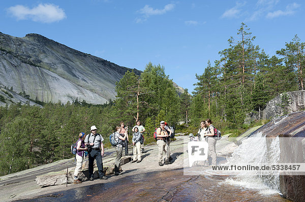 Wandern  Trekking  Wandergruppe steht am Wasserfall  Felsen aus Granit am Berg Roholtsfjell  bei VrÂdal  Vradal  Telemark  Norwegen  Skandinavien  Nordeuropa  Europa