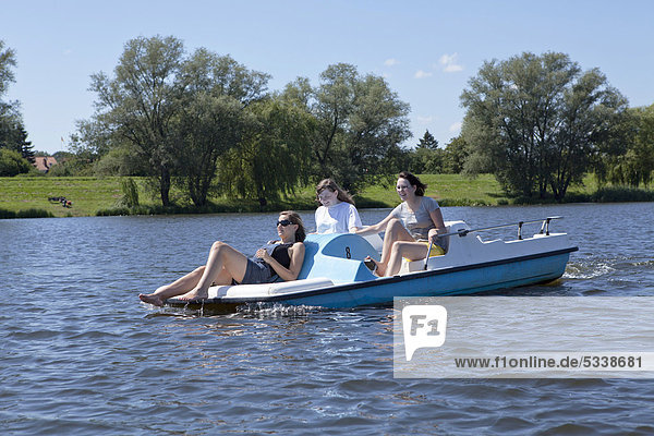 Drei Mädchen beim Tretbootfahren auf dem Gartower See  Naturpark Elbufer-Drawehn  Niedersachsen  Deutschland  Europa