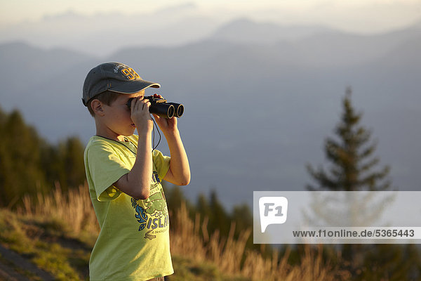 Boy looking through binoculars  Nockberge range  Carinthia  Austria  Europe